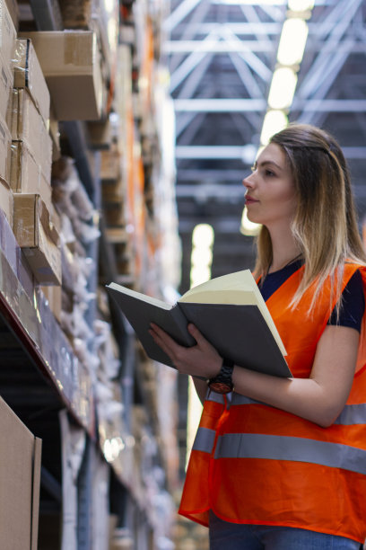 年轻女人控制仓库里的箱子图片下载