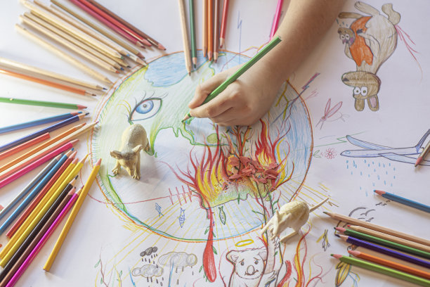 一个孩子在画澳大利亚的火灾，背景是野生动物玩具图片下载
