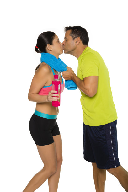 合身的西班牙情侣穿着运动服亲吻。男人亲吻女人。孤立在白色背景上。图片下载