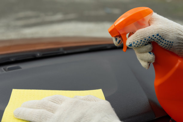 一只戴着白色手套的手用黄色超细纤维布清洗汽车内部的图像。用于车辆沙龙清洁的洗涤剂图片下载