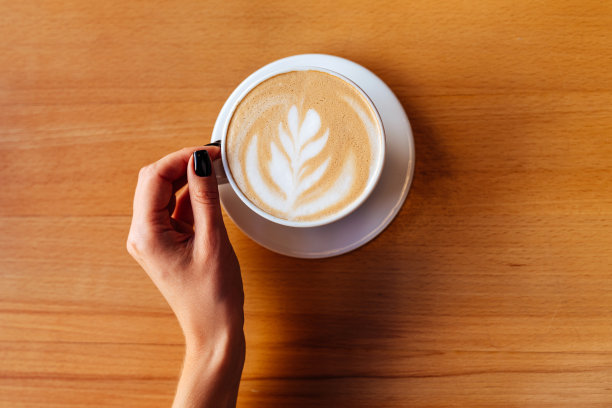 女人的手拿着一杯热咖啡在咖啡馆图片下载