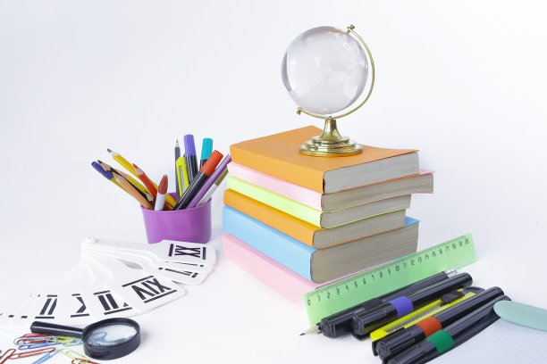 白色背景上的玻璃球、书籍和学习用品图片下载