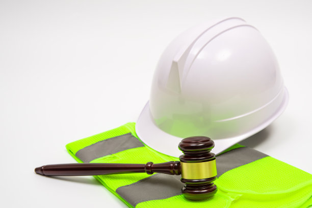 一个与劳动相关的法律概念，安全帽，工作服，和法官的小木槌在白色的背景。图片下载