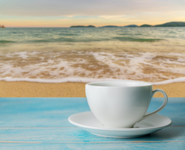 落日或日出迷离的海滩，黄昏时的云天，一杯咖啡图片下载