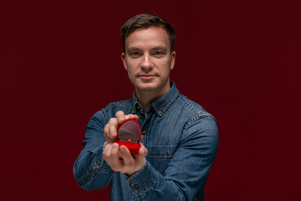 一名年轻男子正在制作带有订婚戒指的求婚盒子。图片下载