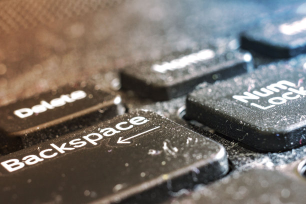 灰尘和肮脏的笔记本电脑键盘特写在黎明，前面和背景模糊的散景效果图片下载