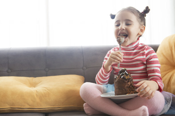 可爱的小女孩在吃巧克力蛋糕图片下载