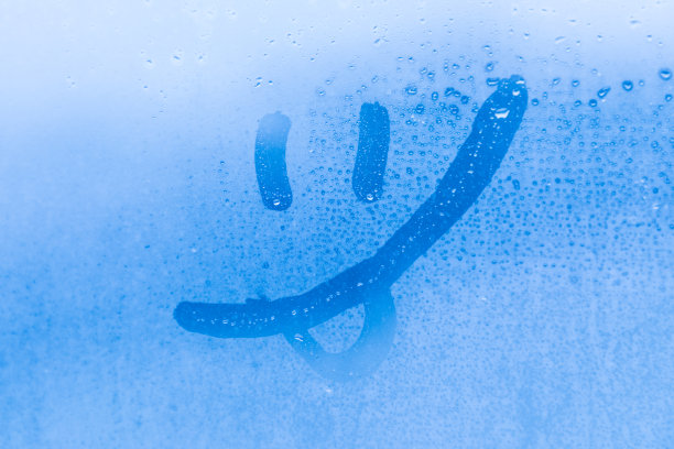 蓝色的黄昏或早晨的窗玻璃上的笑脸的画像或形象图片下载