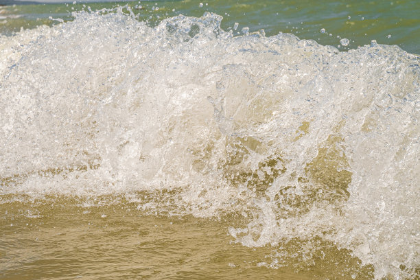 海浪猛烈地落在海岸上。近景潮汐冲浪。图片下载