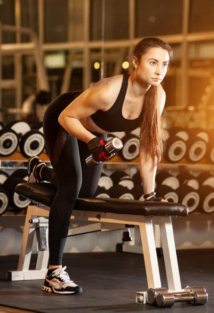 年轻的女运动员在用哑铃做运动图片下载