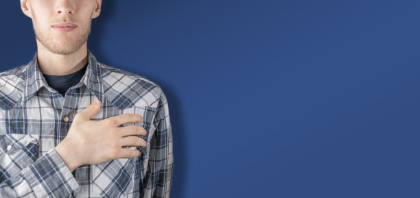 男子将手放在胸前心，以信任和尊重的概念手势抵色墙图片下载