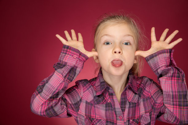 傻傻的脸年轻女孩穿着紫色的衬衫直视着照相机图片下载