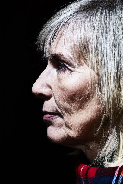 一个在黑色背景下的成熟女人的肖像图片下载