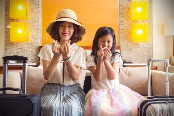 旅行:母亲和小女儿在酒店房间拿着行李图片下载