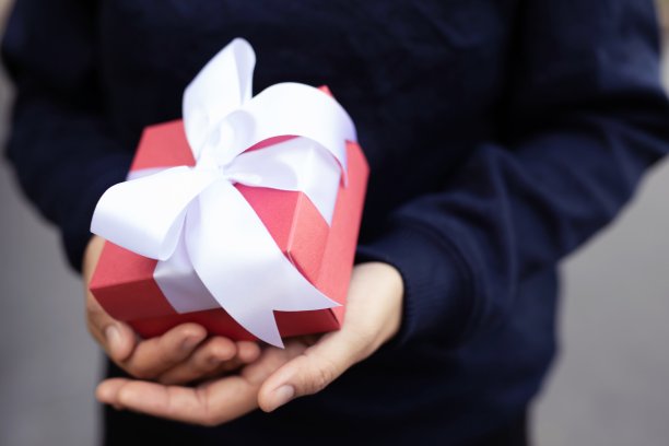 手拿白色丝带礼盒送给情人节的情人图片下载