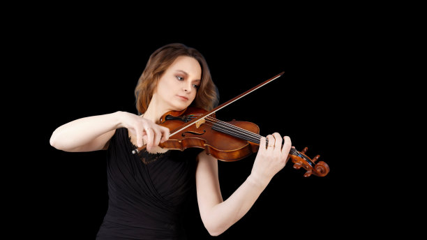 拉小提琴的年轻女子。孤立在黑色背景上。Copyspace。图片下载