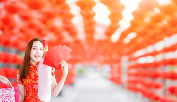 春节快乐。亚洲妇女拿着红包与灯笼的背景。图片下载