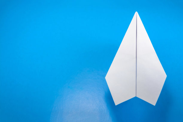 用浅蓝色背景的白纸制成的纸飞机图片下载