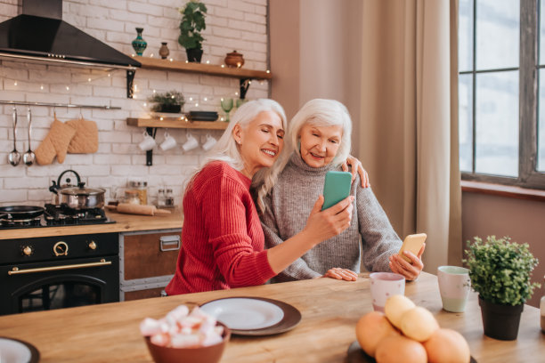 两个成熟的灰白头发的积极的女士在拍照片图片下载