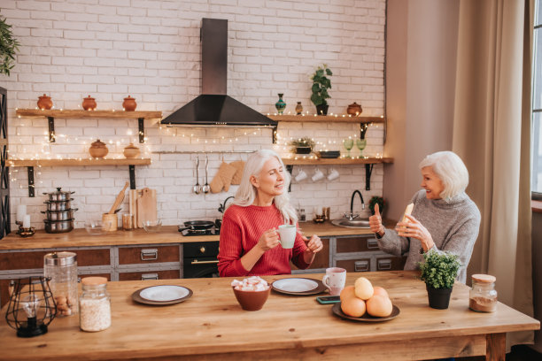 两位成熟的灰头发积极的女士在网上看照片图片下载