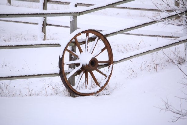 一个木制马车轮子上面有一层雪图片下载