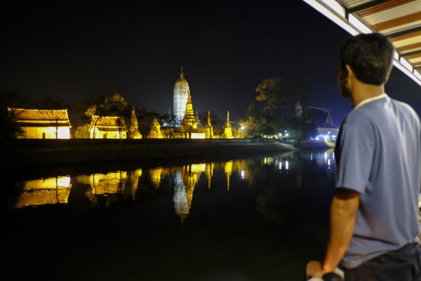 男游客在夜晚参观阿瑜陀耶河畔美丽的寺庙图片下载