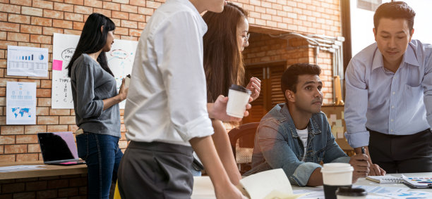 商务人士在创意办公室用笔记本电脑工作。亚洲创意团队会议及工作设计策划理念图片下载