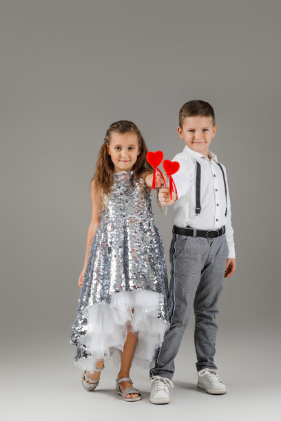 快乐的小女孩和男孩拿着红心图片下载