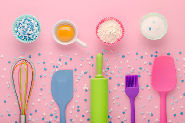 粉色背景上的烘焙材料，鸡蛋，面粉，糖，甜装饰和厨房工具图片下载