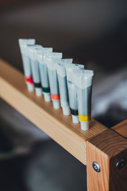 婴儿床边缘的一排丙烯酸漆管图片下载