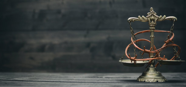 黑色木制背景上是正义的天平和带刺的铁丝网图片下载