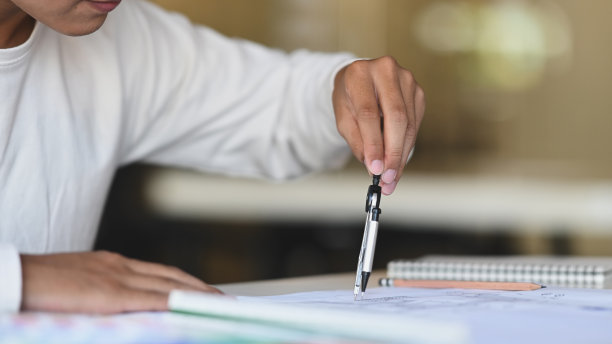 在现代办公室里，建筑师使用铅笔指南针在建筑平面上拍摄的照片。图片下载