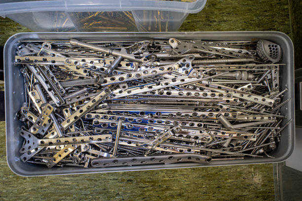 在一个巨大的钢盒子里有许多不同的由钢和钛制成的外科植入物图片下载