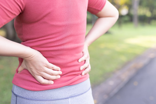 妇女因举重而背痛。图片下载