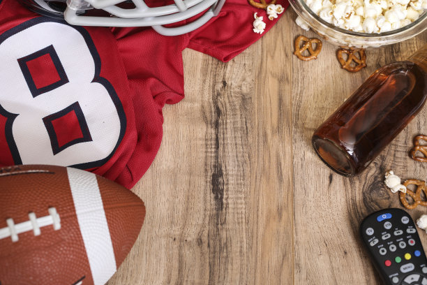 一边看足球比赛一边吃零食，喝饮料。图片下载