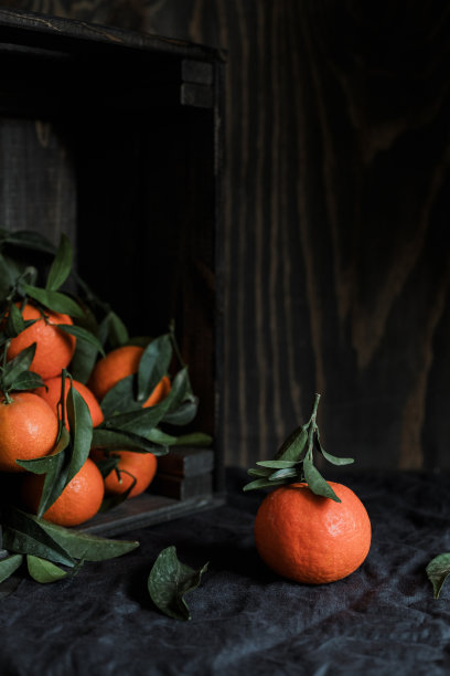 有机成熟的橘子或柑橘，装在木盒里，带叶子图片下载