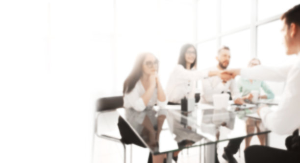 女商人与一位新雇员握手。模糊的背景与复制空间。图片下载