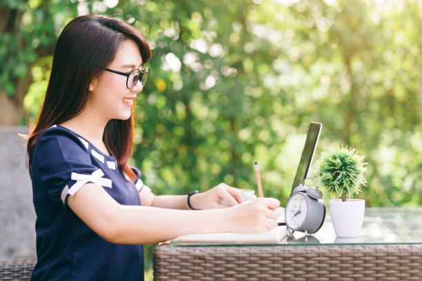 商业亚洲女性工作与笔记，笔记本电脑和时钟在户外办公室。图片下载