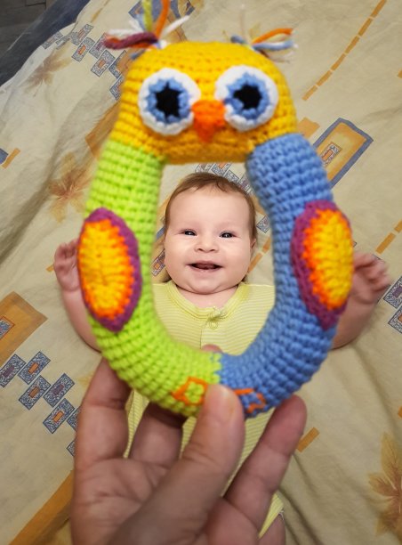 可爱的婴儿在黄色的身体微笑透过明亮的玩具图片下载