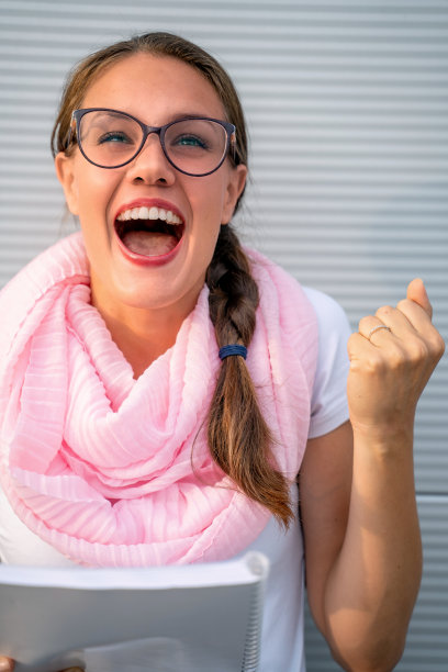 快乐的大学生在考试成功后举起拳头欢呼-库存照片图片下载