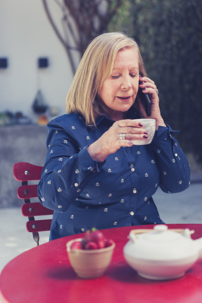 老妇人在后院享受早晨的咖啡图片下载