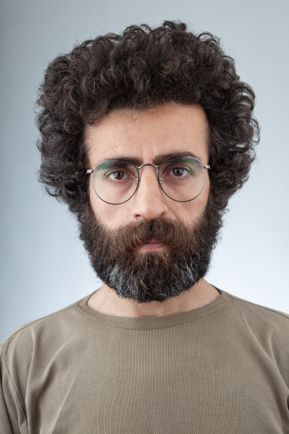 长卷头发和胡子的成年男子的大头照图片下载