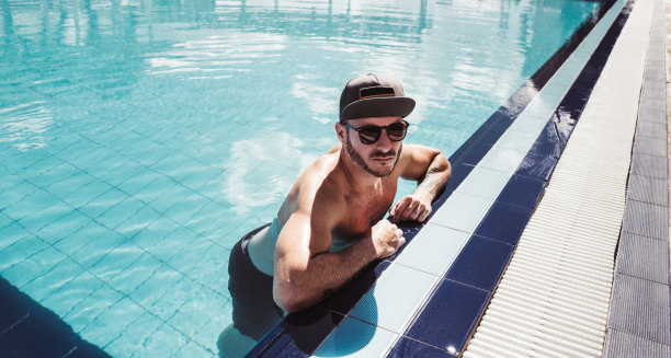 性感的男人在游泳池休息图片下载