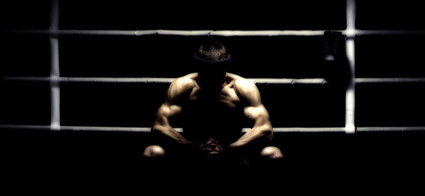 泰拳世界冠军坐在拳击台上，准备迎接下一场比赛。运动、健康生活方式、运动营养概念图片下载