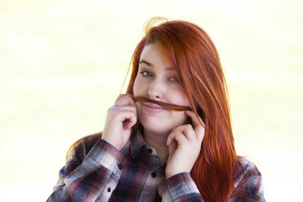 年轻女子用头发做小胡子。图片下载