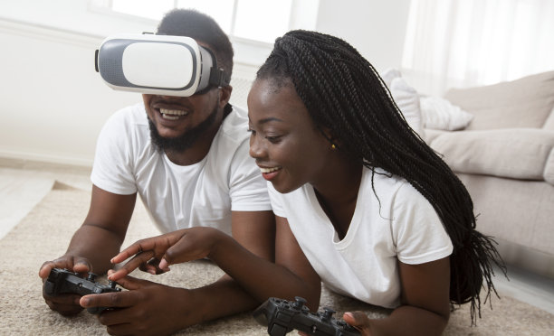 一对快乐的黑人夫妇在家里测试VR眼镜，玩视频游戏图片下载