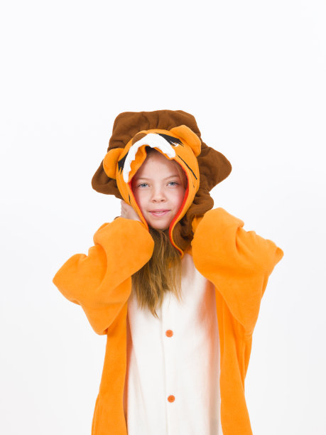 漂亮的金发女孩穿着舒适的狮子服装站在白墙前图片下载