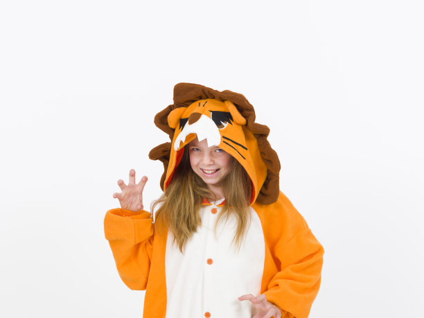 漂亮的金发女孩穿着舒适的狮子服装站在白墙前图片下载