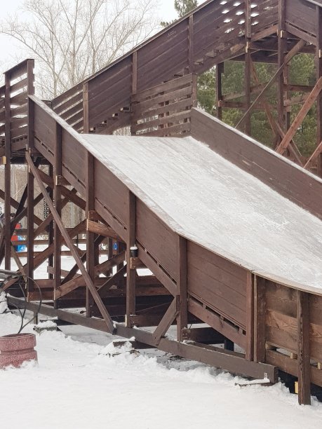 冬季滑雪的木制高架滑梯，在公园里滑雪和娱乐的建筑结构。用手机拍摄的垂直照片。图片下载