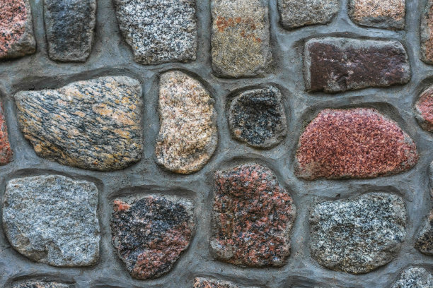 照片中的混凝土墙点缀着美丽的装饰石头图片下载